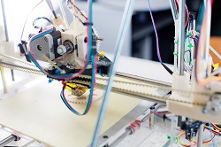 Electronic 3D plastic printer during work in school laboratory